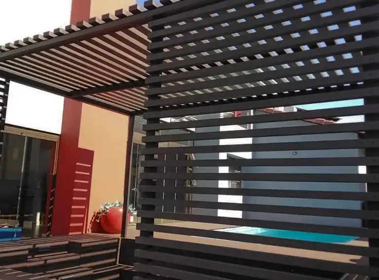 Modern composite cladding and fascia installation with decorative privacy screening and pergola structure at a contemporary home.